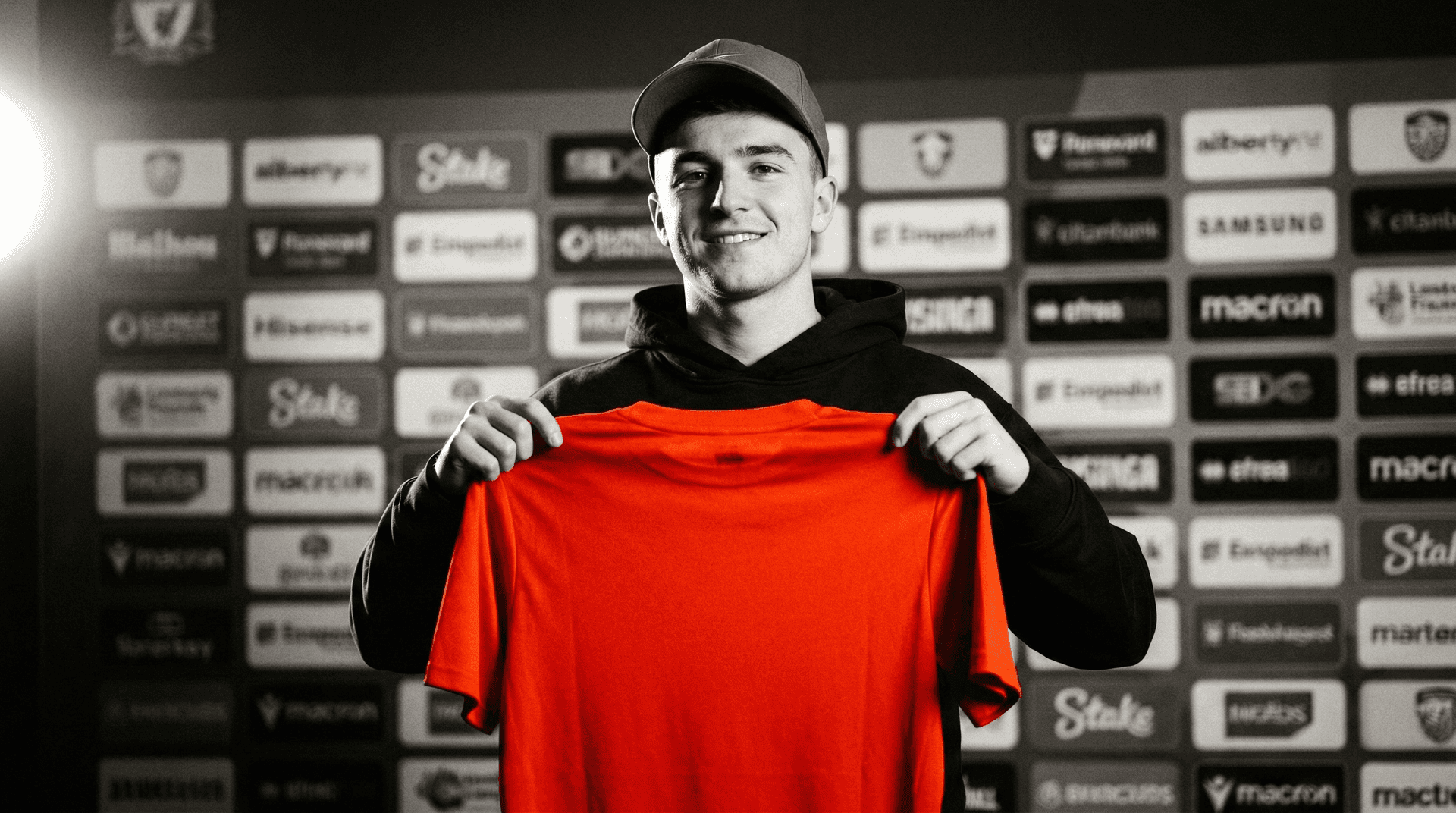 Male fan holding up a red club shirt